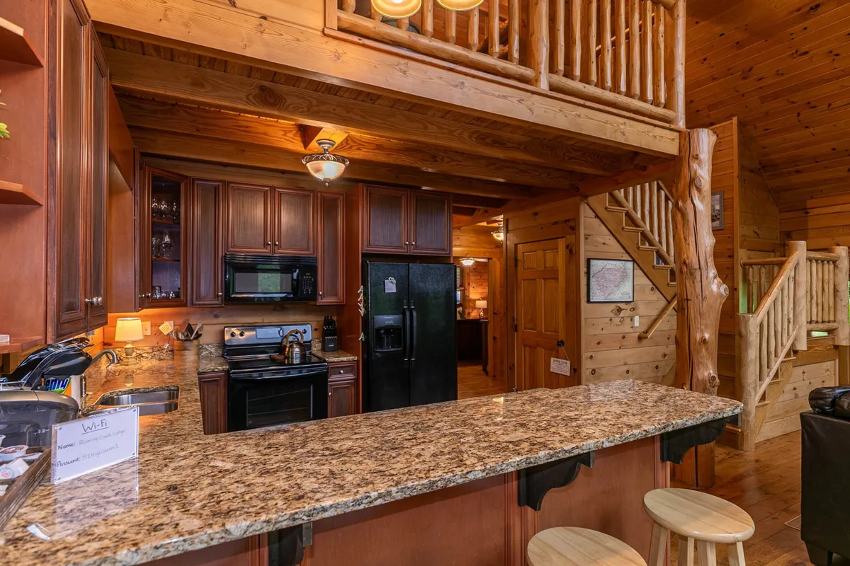 A focused shot of the kitchen area with gleaming granite countertops, wooden cabinetry, and modern kitchen appliances. The open counter with seating encourages conversation, laughter, and shared meal preparation.